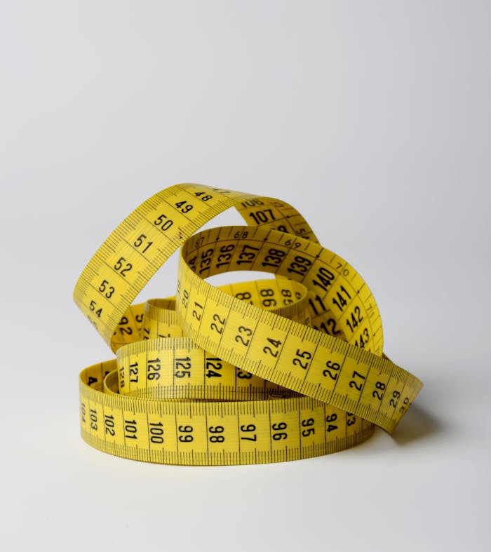 our-story A close-up image of a coiled yellow measuring tape displaying numbers clearly.