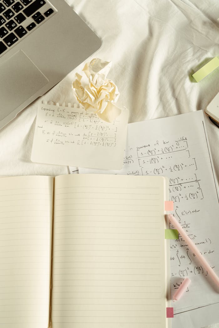 about-bg A flat lay image featuring a laptop, notebooks, and handwritten math notes, ideal for education themes.